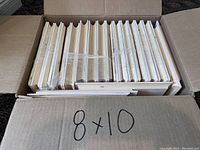 Box containing multiple natural pine plaques stacked together, each 8 x 10 inches, bevelled edges visible on sides.