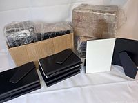 Set of 64 new gloss white photo panels with black easels, still wrapped and boxed.