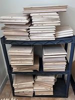 Large lot of stacked bevelled pine plaques on black plastic shelf