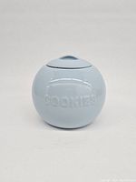 Front view of light blue ceramic cookie jar embossed with COOKIES text