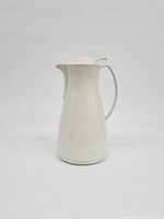 Front view of one white insulated thermal carafe with handle and rounded lid