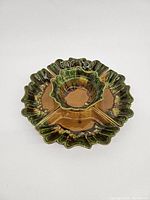 Overhead view of all five interconnected ceramic drip glaze dishes showing earth-toned brown and green color with scalloped edges.