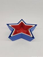Three star-shaped nesting plastic bowls stacked inside each other showing size difference and colors red, white, and blue