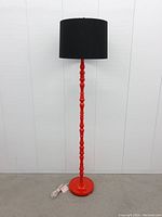 Full view of vintage red IKEA floor lamp with black lampshade showing height and overall design