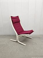 Front angled view of Siesta lounge chair showing white wood frame and red canvas seat with headrest pillow.