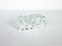 Side view of the rectangular glass crystal paperweight with carved XII design, showing clarity and polished finish.