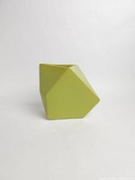 Front-angle view of lime green triangular prism ceramic planter vase on plain white background showing overall geometric shape.