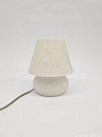 Photo of vintage white jelly mushroom lamp unlit, showing textured mushroom-shaped base and shade with power cord.