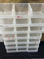 Front view of stacked clear plastic organizer bins arranged in rows, showing 21 bins total.