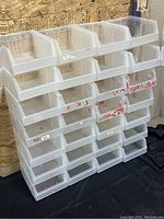 Front view of multiple clear plastic bins stacked in rows, showing size and shape