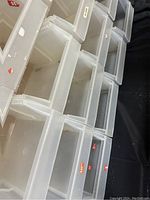 Stack of clear plastic organizer bins from above, showing open fronts and labels