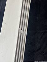 Stacked side view of the lot showing four white wooden shelves stacked together, highlighting the thickness and uniformity.