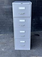 Front view of the gray ProSource 4-drawer filing cabinet showing the handles and label holders on all drawers.