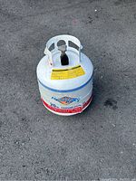Top side view of a white 20lb Flame King propane cylinder showing the valve and handle guard.