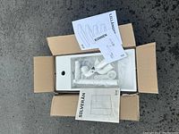 Open box showing white sink and plumbing installation parts including pipes and fittings, along with IKEA instruction manuals labeled LILLANGEN, RINNEN, SILVERAN.