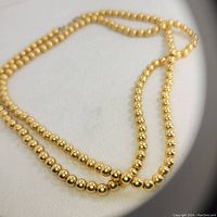 Close-up image of the 1980s Monet gold filled ball chain necklace showing polished gold tone spherical beads.