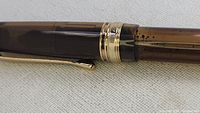 Close-up of the fountain pen showing the brown marbled pattern and gold clip and cap bands