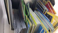 Close up of binders filled with assorted Pokemon cards showing card edges and organized in sleeves and loose