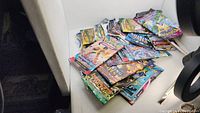 Image showing a pile of assorted unopened Pokémon card booster packs from several series.