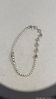Full view of the tennis bracelet showing the tennis chain and star charm segment on a neutral fabric background.