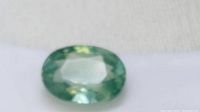 Close-up of oval cut blue-green beryl gemstone.
