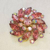 Overall front view of the 1950s mid-century rhinestone brooch showing pink marquise and aurora borealis rhinestones in a swirl floral pattern.