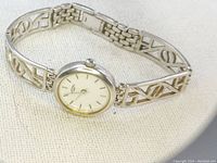 Rotary women's wristwatch with sterling silver 925 case and geometric cutout sterling bracelet shown from angled front view on fabric background.