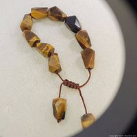 Close-up photo of the handmade bracelet showing the tiger's eye beads and adjustable cord.