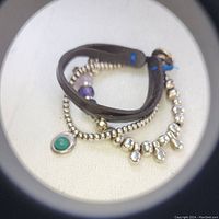 Image showing the bracelet's beads, leather strap, and jade charm.