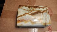 Closed agate carved trinket box showing polished natural agate pattern in white, cream, and brown with smooth glossy surface.