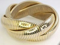 Photo showing front angle of gold tone tri-stretch cuff bracelet with ribbed intertwined bands.