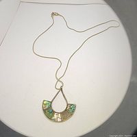 Full view of the silver chain necklace with attached fan-shaped Mexican silver pendant with abalone shell inlay showing color variations.
