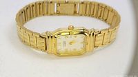 Gold tone Citizen vintage quartz watch showing full band and face, angled view.
