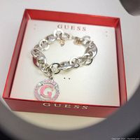 Guess bracelet with circular charm featuring pink G and rhinestones in Guess box