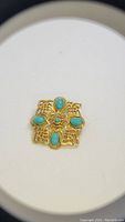 Photo of vintage 14kgf gold-filled brooch showing detailed lattice work and five turquoise stones.