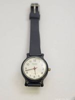 Photo of vintage Cardinal women's quartz watch with black strap and white dial showing watch face and condition.