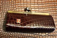 Front view of vintage crocodile leather change purse with textured croc pattern and gold-tone metal frame clasp.