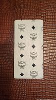 White cream MCM wallet with black repeated logo print on fabric exterior