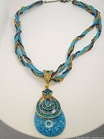 Front view of the vintage statement necklace showing the detailed blue teardrop pendant and twisted multi-strand cord.