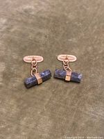 Pair of 14k gold cufflinks with rectangular blue stones secured by gold bands, connected by gold chains to oval toggle closures.