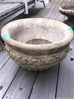Front side view of concrete planter showing sculpted pattern around exterior and thick rim