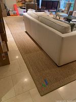 View of rug placed under sofa showing overall coverage and size