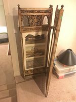 Single panel of the wooden folding screen showing carved wood details and photo inserts