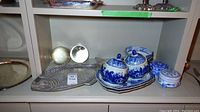 Pewter fish-shaped plate visible with two glass balls behind, blue and white porcelain trinket boxes with lids, set on a matching tray, plus additional round trinket box.