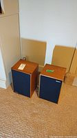 Two Rogers LS2 bookshelf speakers side by side with cloth grills intact