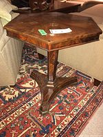 Octagonal wooden side table shown from a corner angle, illustrating overall design and wood grain pattern on top.