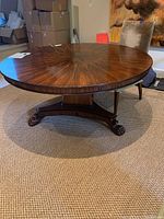 Angled full view showing round top, pedestal base and claw feet