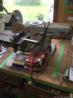 Side view showing the disc sander, sanding table, and circular sanding disc.