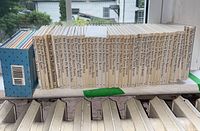 Photo of the spines of the Beatrix Potter book series showing multiple white hardcovers with black text titles such as The Tale of Peter Rabbit and others.