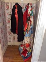 Full view of navy cloak and multicolor crane robe hanging together